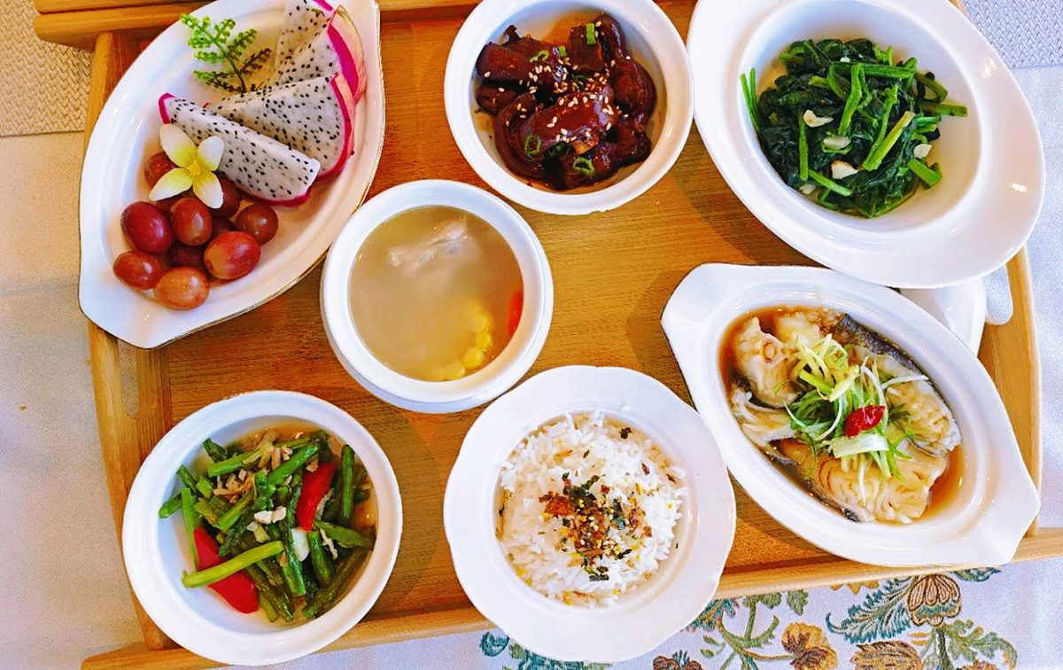 Postpartum meal with steamed fish, fruit and greens